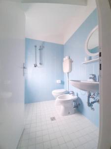 bagno blu con servizi igienici e lavandino di Hotel Amalfi a Rimini