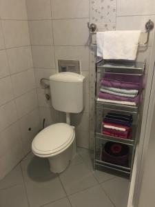 La petite salle de bains est pourvue de toilettes et de serviettes. dans l'établissement Nikka Apartments, à Malinska