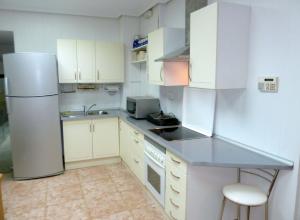 a kitchen with white cabinets and a refrigerator at La SUCURSAL in Cazalegas