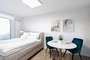 a bedroom with a bed and a table with chairs at Apartment Gartenblick - 1 Zi, Küche, Duschbad, Terrasse sowie Gartenmitbenutzung in Bayreuth