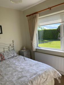1 dormitorio con cama y ventana grande en Lahinch View en Doolin