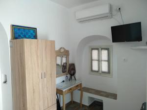 een kamer met een bureau en een tv aan de muur bij Melissou place in Apollonia