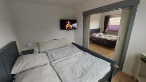 Un dormitorio con una cama blanca y un espejo. en Ferienhaus Am Oland, en Büsum