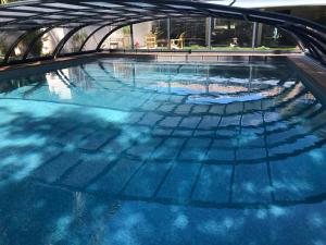 LA MAISON DE LA DUNE - Chambres Climatisées - Jacuzzi 1ère séance offerte - Piscine chauffée avec Abri Amovible - Plage située à 200m, accès direct par le bois内部或周边的泳池