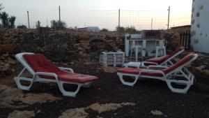two chairs with red cushions sitting in a yard at Villa Cecilio in Tefía