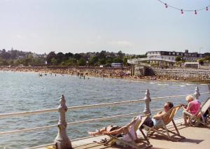 a group of people sitting in lawn chairs on the beach at The Rosewood Torquay in Torquay