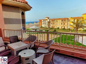 a balcony with chairs and tables and a view of the ocean at Chalets in Porto Matrouh Families Only in Marsa Matruh