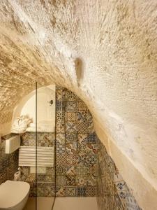 La Casa nel Vico في سيغلي ميسابيكا: حمام به مرحاض وجدار حجري