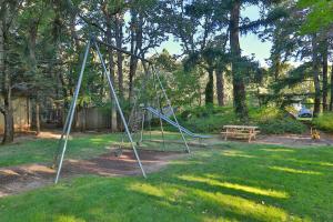 a swing set in a yard with a bench at Westcliff Lodge in Hood River