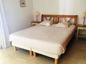 a bedroom with a large white bed with two tables at Villa Sévigné in Gréoux-les-Bains