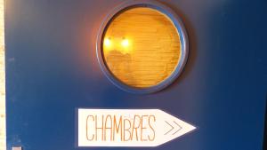 a sign on a blue wall with a window at Mon P'tit Hôtel in Le Grau-dʼAgde