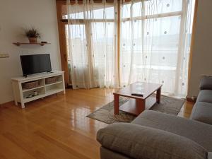 sala de estar con sofá y TV en Chalet en Combarro a pie de playa, en Poio