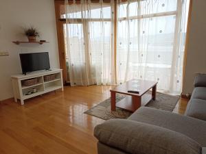 a living room with a couch and a tv at Chalet en Combarro a pie de playa in Poio