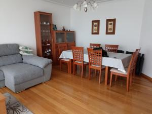 a living room with a table and chairs and a couch at Chalet en Combarro a pie de playa in Poio