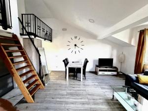 a living room with a table and a clock on the wall at Apartment Madison in Cavtat