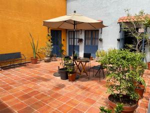 a patio with a table and an umbrella and plants at Casa Arrayan in Guadalajara