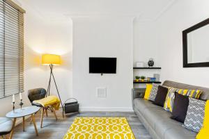 a living room with a couch and a tv on a wall at Spacious & Central Entire Home in Nottingham