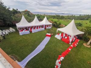 a group of white tents with red and white chairs at Victoria Lake View Guesthouse & Safaris in Entebbe