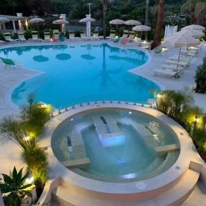 a large pool with blue water in a resort at Les Sables Noirs & Spa Multiproprietà in Vulcano