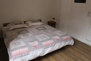 a bedroom with a bed with a quilt on it at Gite l'Aiguillette du Lauzet in Le Monêtier-les-Bains