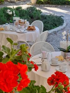 a table with plates of food and red flowers at Parkhotel Montigeto in Passignano sul Trasimeno