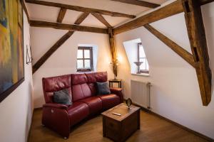 een woonkamer met een rode bank en een tafel bij Rißbacher Hof Mansarde anno 1737 in Traben-Trarbach
