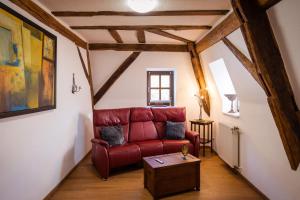 a living room with a red couch and a table at Rißbacher Hof Mansarde anno 1737 in Traben-Trarbach