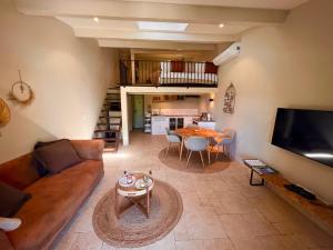 a living room with a couch and a table at Le Mouron Rouge in La Garde-Freinet