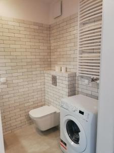 Apartament Dolny Sopot في سوبوت: حمام مع غسالة ومرحاض