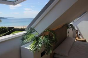 balcón con sofá y vistas al océano en Hotel Playa de Sardiñeiro, en Finisterre