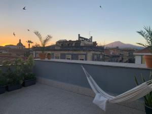 a hammock on a balcony with a view of a city at Homestay in Catania