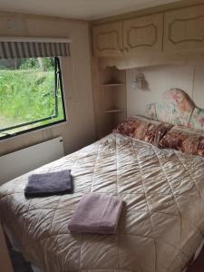 a bedroom with a bed with two towels on it at Lochlands caravan park X(6) in Forfar