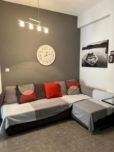 duża kanapa w pokoju z zegarem na ścianie w obiekcie Central Kalamata Cozy Apartment w Kalamácie