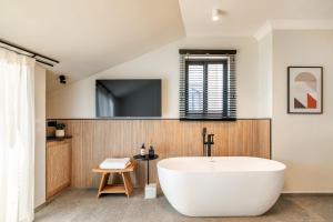 a bathroom with a white tub and a tv at Albi Boutique Hotel - Traveler's Choice 2024 in Jerusalem