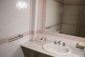 La salle de bains est pourvue d'un lavabo et d'un miroir. dans l'établissement Toscana Wellness Resort, à Arcidosso
