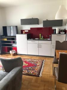 a kitchen with white cabinets and a red wall at Haus Wieser in Lienz