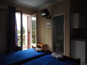 a bedroom with a large blue bed and a window at ChiosRoomsMaria in Armólia