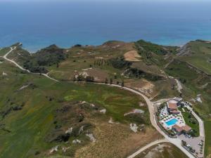 an aerial view of a house on a hill next to the ocean at Tramonto Suites in Xi