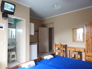 a bedroom with a blue bed and a kitchen at ChiosRoomsMaria in Armólia