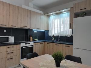 a kitchen with a table and a white refrigerator at CENTRAL TOWN HOUSE 60m2**** in Piraeus