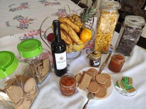 uma mesa com uma garrafa de vinho e um cesto de comida em Casa Quinta Da Nogueira no Pinhão