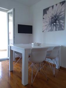 a white table with two chairs and a tv on a wall at Apartments Rea in Cres