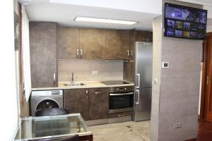 a kitchen with a stainless steel refrigerator and a dishwasher at Apartamentos Zarautz Playa2, con piscina y garaje in Zarautz