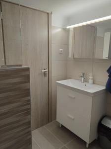 a bathroom with a sink and a wooden door at CENTRAL TOWN HOUSE 60m2**** in Piraeus