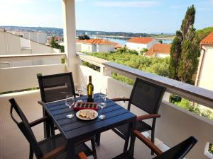 a table with a plate of food on a balcony at Apartmani Tamarut in Novalja