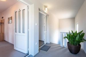 een hal met een deur en een potplant bij Apartman Harfa 1 in Orebić