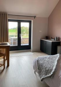 een slaapkamer met een bed en een keuken met een raam bij B&B Aasterbergerhoeve in Echt
