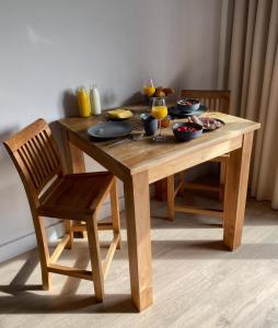 een houten tafel en stoel met eten erop bij B&B Aasterbergerhoeve in Echt