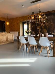 een eetkamer met een tafel en witte stoelen bij B&B Aasterbergerhoeve in Echt