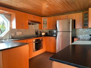 a kitchen with wooden cabinets and a stainless steel refrigerator at Paradis de Charlevoix - Loft in Baie-Saint-Paul